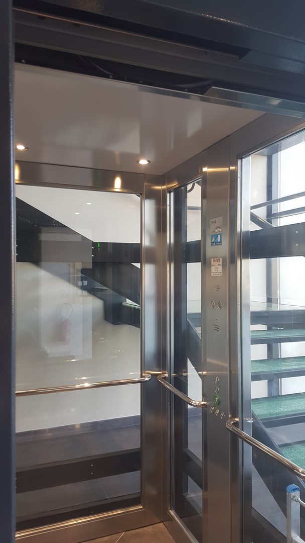 Cabine d'ascenseur en inox et verre dans un bâtiment professionnel
