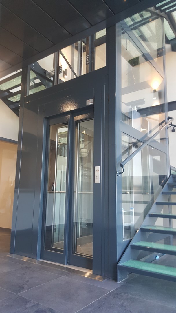 Ascenseur en gaine métallique anthracite dans un grand bâtiment