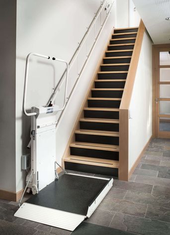 Élévateur d'escalier déployé au pied d'un escalier intérieur